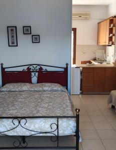 a bedroom with a large bed and a kitchen at Panorama Appartment in Agia Marina