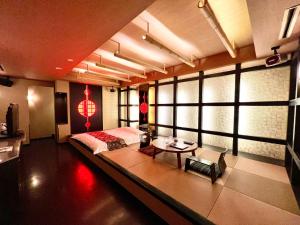 a room with a bed and a table in it at SKY JZauruss バズるホテル ,Dinosaur Love Hotel in Beppu