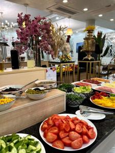 a buffet with plates of food on a counter at Navruz Hotel Tashkent in Tashkent