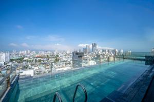 a swimming pool on the roof of a building with a city at San Marino Boutique Danang - 10 mins to Dragon Bridge & 15 mins to My Khe Beach in Da Nang