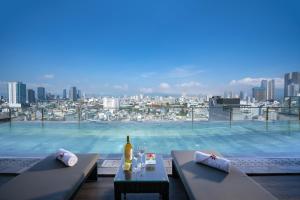 a large swimming pool with a table and a bottle of wine at San Marino Boutique Danang - 10 mins to Dragon Bridge & 15 mins to My Khe Beach in Da Nang