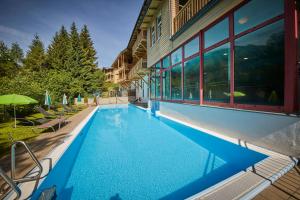a swimming pool in front of a building at AlpenParks Premium Apartment Rehrenberg II in Viehhofen