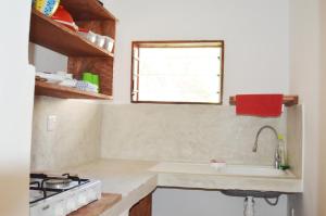 a kitchen with a sink and a stove and a window at MARIA, the Star on the sea beach cottages - cottage JIRANI in Malindi +17 photos