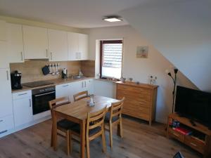 a kitchen with a table and chairs and a television at Dünenrose in Horumersiel