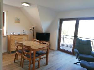 a dining room with a table and chairs and a television at Dünenrose in Horumersiel
