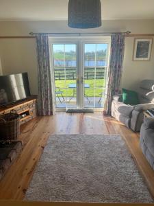 ein Wohnzimmer mit einem Sofa und einer Glasschiebetür in der Unterkunft Laraghson House in Enniskillen