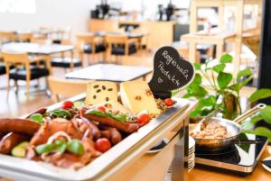 a tray of food on a table with cheese and sausage at Vienna House by Wyndham Martinspark Dornbirn in Dornbirn