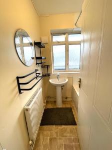 a bathroom with a sink and a mirror at Charming double-bedroom in London Flat in London