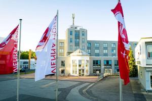 un grupo de banderas frente a un edificio en Vienna House Easy by Wyndham Coburg en Coburg