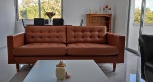 a brown leather couch in a living room with a table at Ellas Modern Duplex City Center in Nicosia