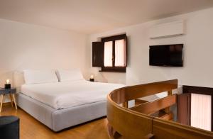 um quarto com uma cama branca e uma televisão em Navona 80 Loft em Roma
