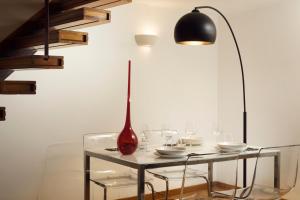 uma mesa com óculos e um vaso vermelho em Navona 80 Loft em Roma