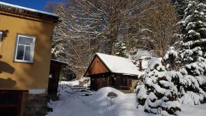 een hut in de sneeuw naast een huis bij Ubytování U Trůdy in Smržovka