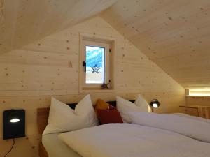 een slaapkamer met 2 bedden en een raam bij Ferienhäuser Stiva Pintga 