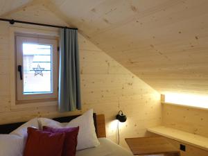 Zimmer mit einem Bett und einem Fenster in einer Hütte in der Unterkunft Ferienhäuser Stiva Pintga 