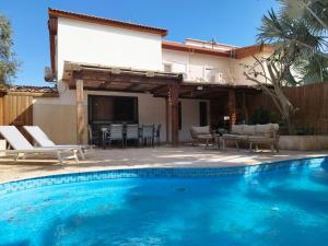 a swimming pool in front of a house at YalaRent Fruit Tree Villa with Private Pool in Eilat