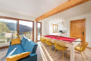 sala de estar con sofá azul y mesa de billar en Le Cerf, chalet cocooning avec piscine et billard en Ban-sur-Meurthe-Clefcy