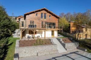 duży drewniany dom z tarasem i dziedzińcem w obiekcie Le Cerf, chalet cocooning avec piscine et billard w mieście Ban-sur-Meurthe-Clefcy