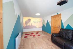 salon z kanapą i obrazem na ścianie w obiekcie Le Cerf, chalet cocooning avec piscine et billard w mieście Ban-sur-Meurthe-Clefcy