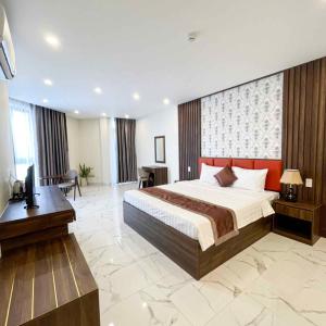 um quarto com uma cama, uma secretária e uma televisão em Marina Hotel Bình Dương em Thu Dau Mot
