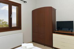a living room with a tv and a entertainment center at Elli's view studio in Episkopíon