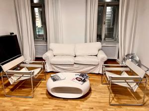 ブダペストにあるVintage vibes super central flatのリビングルーム(白いソファ、椅子付)