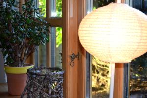 uma lâmpada e uma planta com vaso ao lado de uma janela em Holmgård em Süderholm