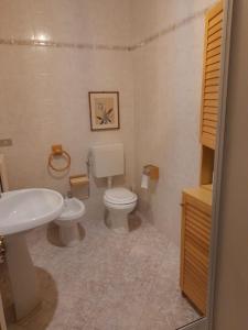 een badkamer met een wit toilet en een wastafel bij Lovely place in Passignano sul Trasimeno