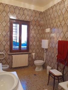 een badkamer met een toilet en een raam bij Lovely place in Passignano sul Trasimeno