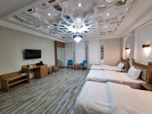 a hotel room with four beds and a television at Latifa Begim Boutique Hotel in Bukhara