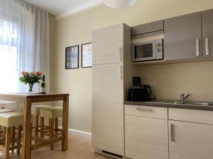a kitchen with a table and a microwave at MOMENTS Ferienwohnungen - Goschwitzstraße 27 A in Bautzen