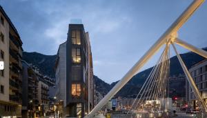 eine Brücke über eine Stadt mit einem hohen Gebäude in der Unterkunft PLAN B City Center Aparthotel in Andorra la Vella
