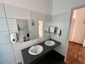a bathroom with two sinks and two mirrors at Casaroma Hostels in Lima +56 photos