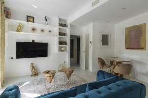 THE CLOCK HOUSE Luxury Urban Suites في مالقة: غرفة معيشة مع أريكة زرقاء وطاولة