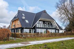 een huis met een schilddak bij Haus Badestrand Badestrand 3 in Born