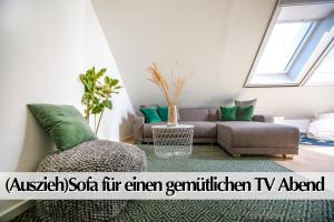 sala de estar con sofá y almohadas verdes en Helle 72qm Maisonette Wohnung im Herzen Erfurts mit Kingsize Bett, Smart-TV, etc, en Erfurt