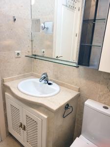 uma casa de banho com um lavatório, um WC e um espelho. em El Oasis de las Palmeras @ Roda Golf & Beach resort em San Javier
