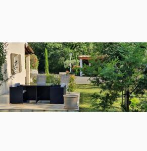 eine Terrasse mit einem Tisch und einem Baum im Hof in der Unterkunft Appartement 2 pièces en rez de jardin de 60m2 in Peymeinade