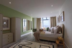 a bedroom with a bed and a large window at Luxury 1BR Seafront Apartment in Cardiff