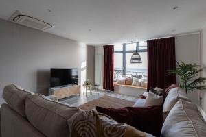 a living room with a couch and a tv at Luxury 1BR Seafront Apartment in Cardiff