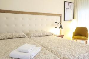 a bedroom with a bed with two towels on it at Hotel Playa Canet in Canet de Berenguer