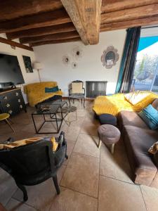 a living room with couches and chairs and a large window at Le Val de Nodicia in Montlivault