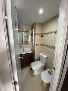 a bathroom with a toilet and a sink at Apartamento Cuzco in Madrid