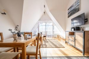 a dining room with a table and a dog in a room at Apartamenty Jasiowe Turnie nr 3 i nr 10 Krupówki 3km in Kościelisko