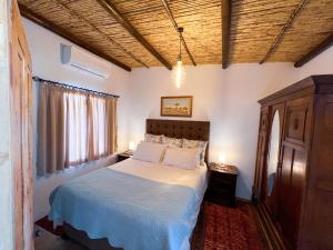 Un dormitorio con una cama con sábanas blancas y una ventana. en Prince Albert Cottage, en Prince Albert