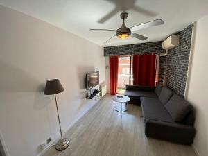 uma sala de estar com um sofá e uma ventoinha de tecto em Apartamento Cuzco em Madri