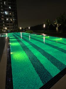 a swimming pool with green lights at night at Homestay Cikgu Wanzarif@Bangi in Kampong Tangkas