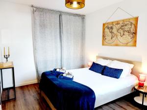 a bedroom with a white bed with blue sheets at Appartement Résidentiel avec parking/Proche Centre in Angoulême