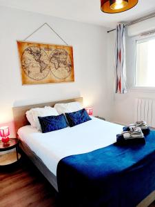 a bedroom with a large white bed with blue sheets at Appartement Résidentiel avec parking/Proche Centre in Angoulême