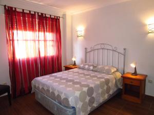 ベナルマデナにあるBenalromaのベッドルーム1室(赤いカーテンとランプ2つ付)